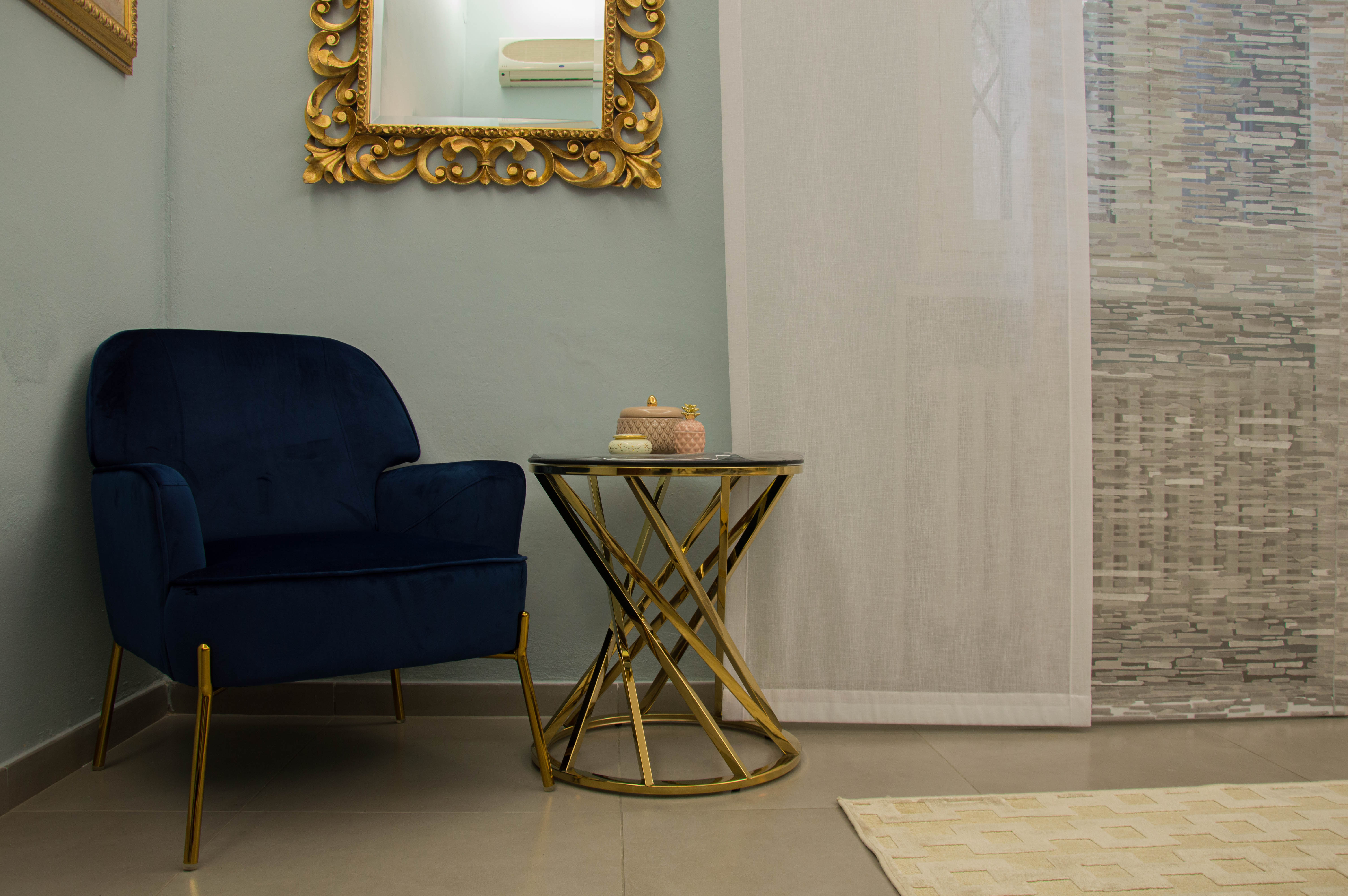 Poltrona blu e tavolino dorato in camera